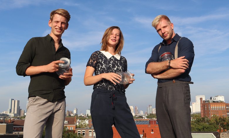 De 3 initiatiefnemers staan naast elkaar met een stad op de achtergrond